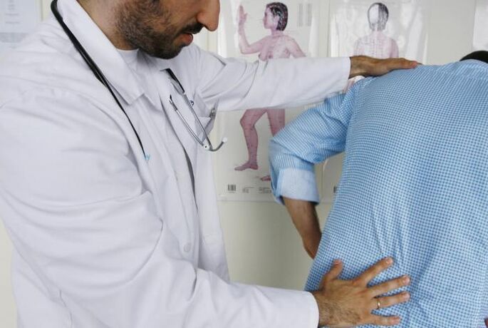 Doctor examining a patient with back pain in the lower back
